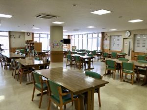 明るい食堂・ダイニングエリア。複数のテーブルと椅子が配置されている共用食事スペース。